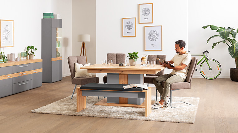 LIV’IN Speisen bei Moebel-Shop - Essgruppe mit Massivholztisch, gepolsterten Stühlen und passender Sitzbank mit Rückenlehne. Sideboard und Vitrine in Grau mit Holzdekor runden das moderne Wohnkonzept ab.