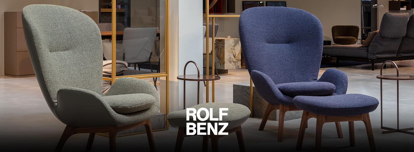 ROLF BENZ Sessel & Hocker - In einem Showroom präsentierte ROLF BENZ Sessel in Blau und Grün mit Holzuntergestell, dazu passende ROLF BENZ Hocker