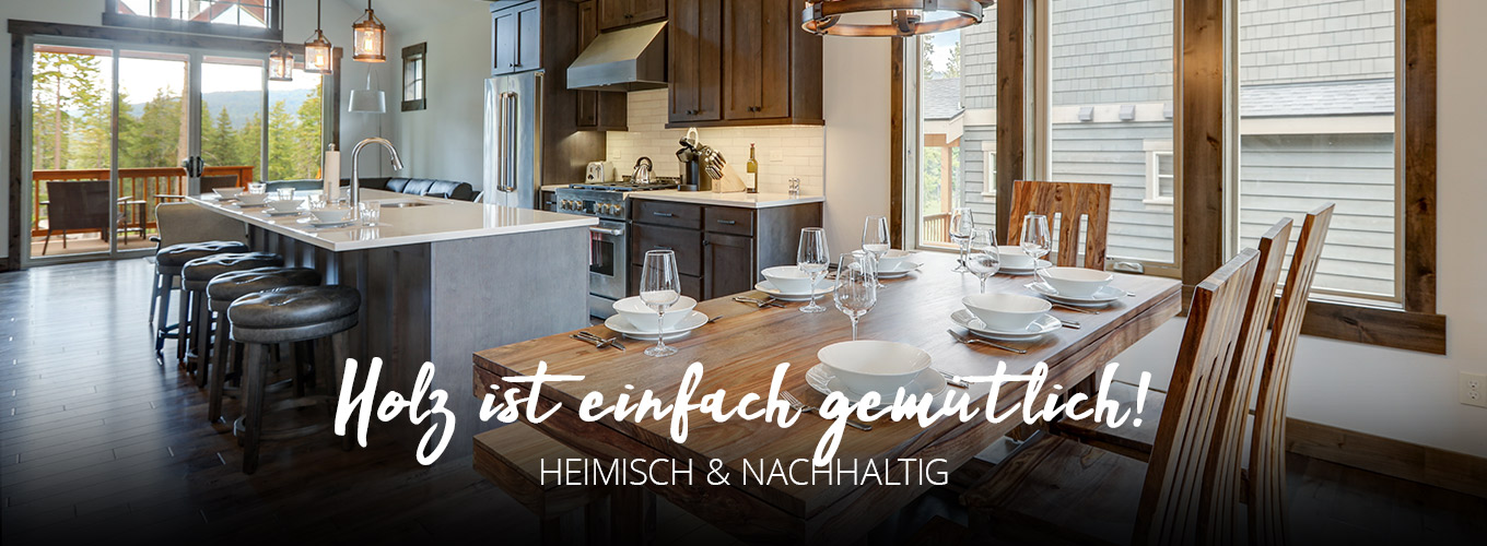 Holz ist einfach gemütlich - Heimisch & nachhaltig - Küche aus Holz in einem Raum mit Holz-Fensterrahmen, freigelegten Dachbalken und im Vordergrund ein Esstisch aus Holz