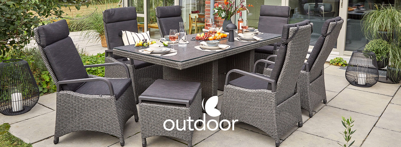 outdoor bei Moebel-Shop - Eine outdoor Garten-Sitzgruppe in Anthrazit aus Kunststoff-Rattan-Geflecht, bestehend aus outdoor Gartenstühlen, Hockern und einem outdoor Gartentisch auf einer Terrasse mit Grünpflanzen