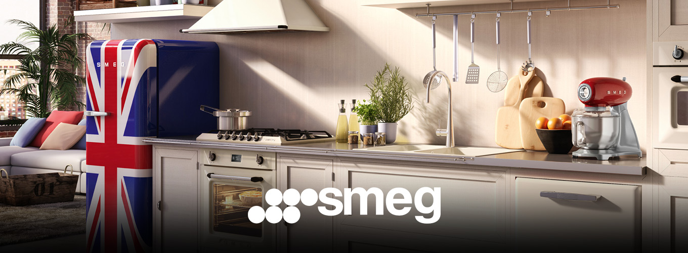 smeg bei Moebel-Shop – Helle Landhausküche in offenem Loft, ausgestattet mit SMEG Küchengeräten. Roter Toaster und rote Küchenmaschine setzen Akzente, am Rand steht ein Retro-Kühlschrank mit britischer Flagge.