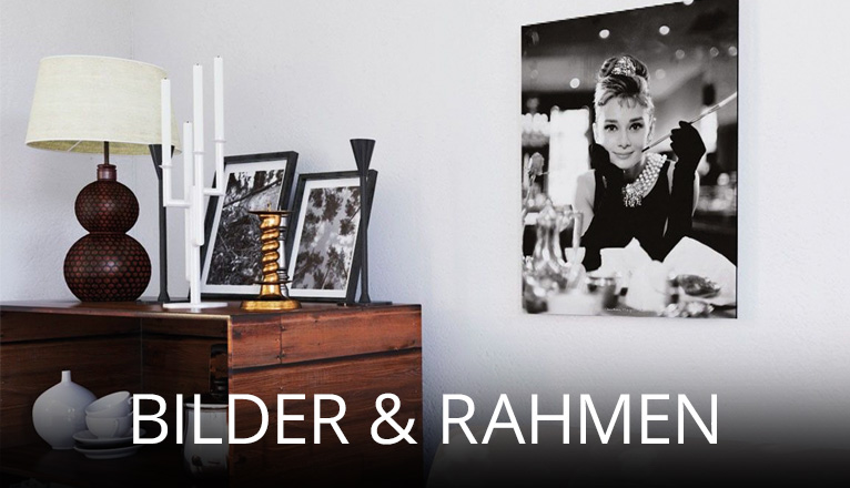 Dekorativer Wohnbereich mit Wandbild in Schwarz-Weiß, mehreren gerahmten Fotos auf einer Kommode sowie stilvollen Accessoires wie Lampe und Kerzenhaltern, die eine elegante Atmosphäre schaffen