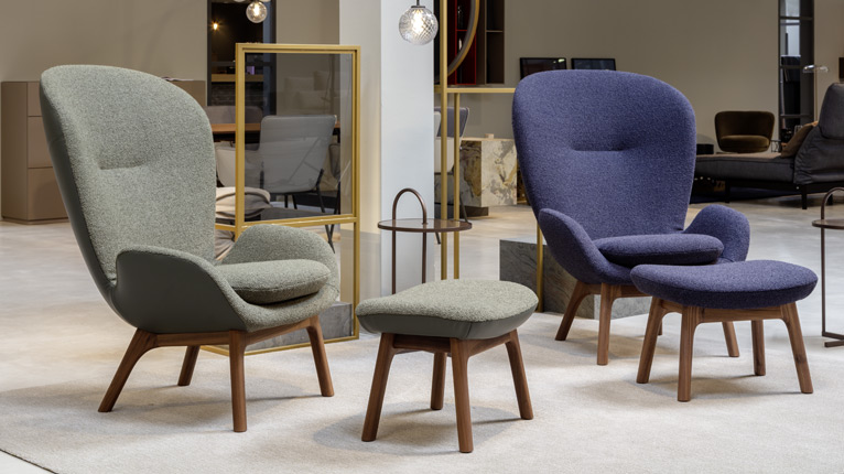 ROLF BENZ Sessel & Hocker - In einem Showroom präsentierte ROLF BENZ Sessel in Blau und Grün mit Holzuntergestell, dazu passende ROLF BENZ Hocker