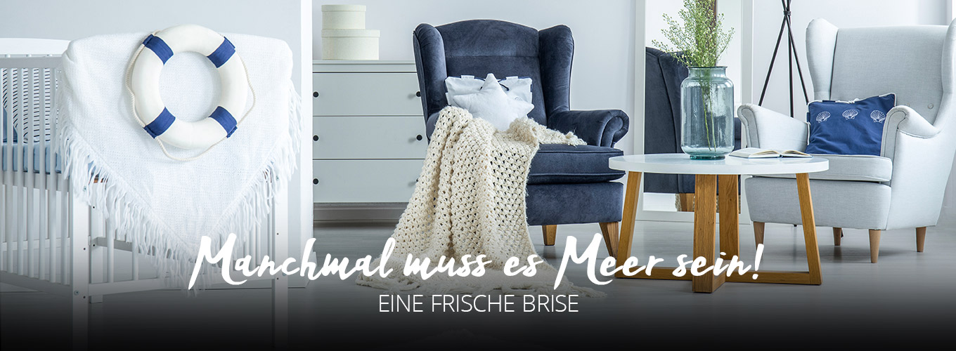 Manchmal muss es Meer sein - Eine frische Brise - Gemütliche helle Sitzecke mit Ohrensesseln in Blau, Grau und Weiß mit Kissen und Decken. Maritime Accessoires wie Anker und Rettungsring.