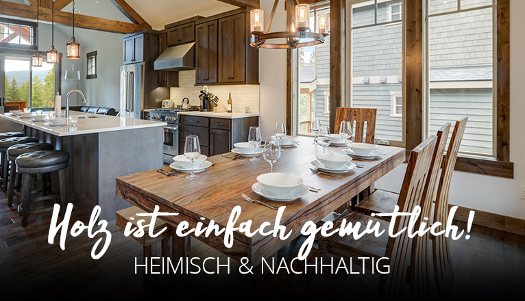 Holz ist einfach gemütlich - Heimisch & nachhaltig - Küche aus Holz in einem Raum mit Holz-Fensterrahmen, freigelegten Dachbalken und im Vordergrund ein Esstisch aus Holz