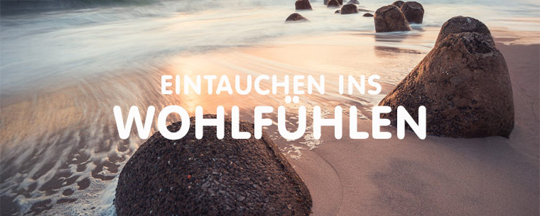 Eintauchen ins Wohlfühlen - Große runde Felsen am Strand mit unscharfer Wasserbewegung in Abendstimmung mit Gegenlicht