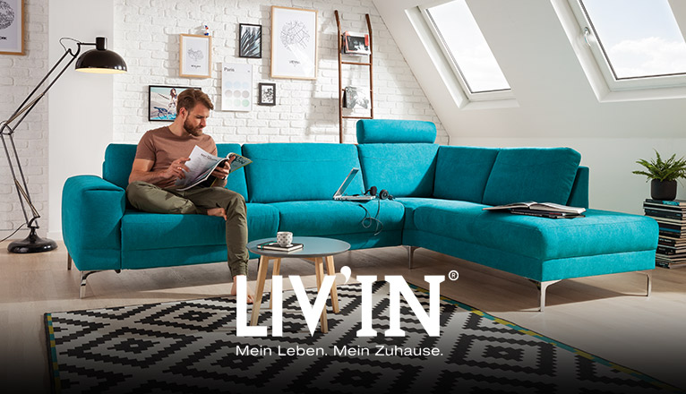 LIV’IN Polster bei Moebel-Shop - Ecksofa in Türkis mit verstellbarer Kopfstütze und filigranen Metallfüßen. Runder Beistelltisch aus Holz und Teppich im grafischen Schwarz-Weiß-Muster ergänzen das moderne Ambiente.