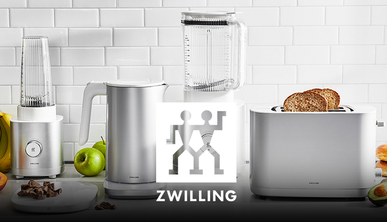ZWILLING Enfinigy-Serie mit kleinem Standmixer, Wasserkocher, großem Standmixer und Toaster; umgeben von Obst und Brot.