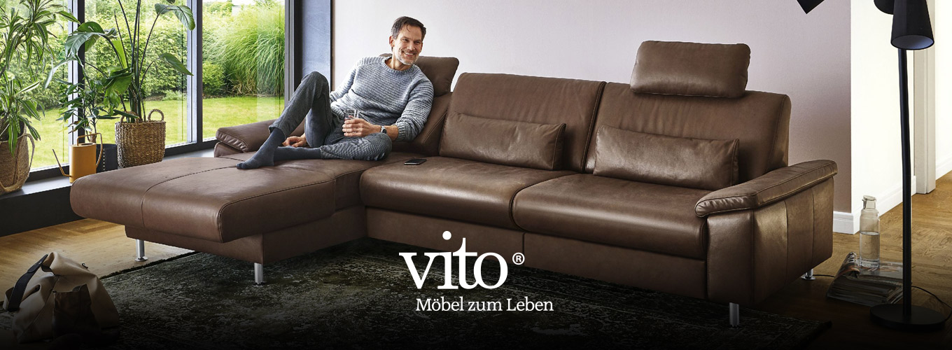 vito Sofas bei Moebel-Shop - Ein Mann sitzt entspannt auf einem braunen vito Ledersofa mit einem Glas Wasser in der Hand