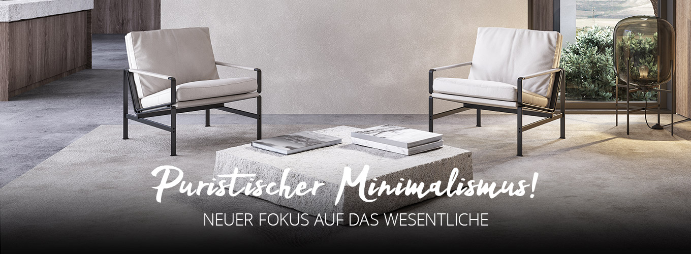 Puristischer Minimalismus - Neuer Fokus auf das Wesentliche - Zwei schlichte Sessel und ein tiefer Tisch aus einem weißen quaderförmigen Stein in einem hellen Raum in reduzierter Betonoptik