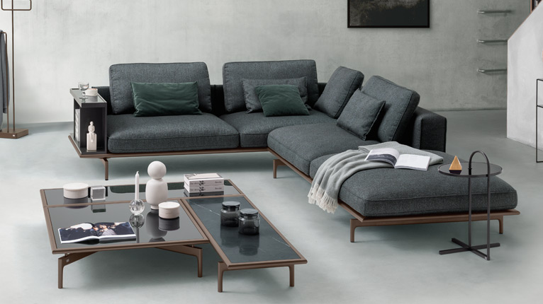 ROLF BENZ Sofas - Ein hellgraues ROLF BENZ Sofa mit passendem ROLF BENZ Couchtisch in einem Wohnzimmer mit Wänden und Boden in Beton-Optik