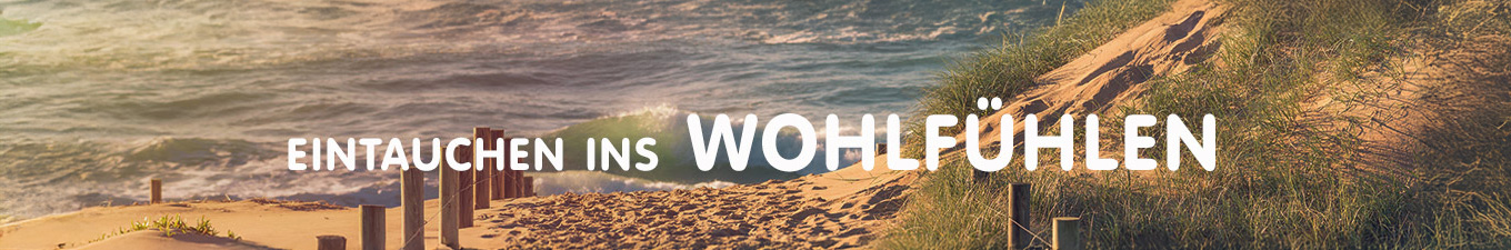 Eintauchen ins Wohlfühlen - Große runde Felsen am Strand mit unscharfer Wasserbewegung in Abendstimmung mit Gegenlicht
