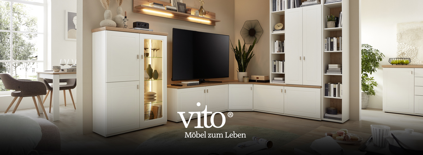 vito Wohnen bei Moebel-Shop - Eine weiße vito Holz-Eck-Wohnwand mit beleuchteten Vitrinen-Elementen, Bücher und Dekoration sind passend gewählt