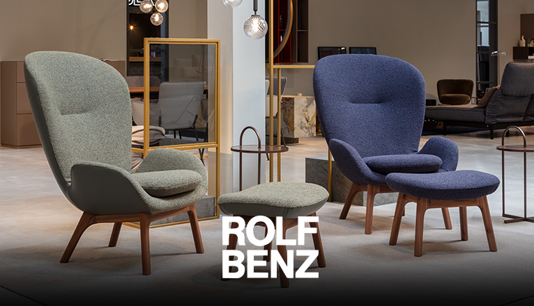 ROLF BENZ Sessel & Hocker - In einem Showroom präsentierte ROLF BENZ Sessel in Blau und Grün mit Holzuntergestell, dazu passende ROLF BENZ Hocker