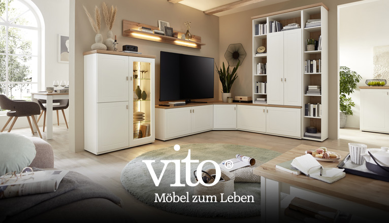 vito Wohnen bei Moebel-Shop - Eine weiße vito Holz-Eck-Wohnwand mit beleuchteten Vitrinen-Elementen, Bücher und Dekoration sind passend gewählt