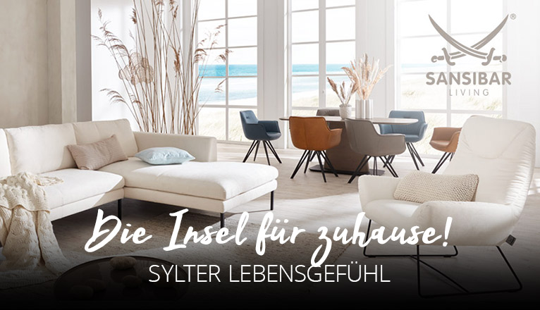Die Insel für Zuhause - Sylter Lebensgefühl - Ein cremefarbenes Ecksofa in hellem Raum mit großen Sprossenfenstern und natürlicher Dekoration, ein Esstisch mit farbigen Stühlen im Hintergrund