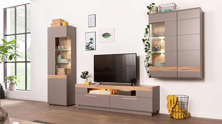 LIV’IN Wohnen bei Moebel-Shop - Wohnwand mit TV-Board, Hängevitrine und beleuchteter Standvitrine in Taupe mit Holzakzenten. Klare Linien und viel Stauraum sorgen für ein modernes, wohnliches Ambiente.