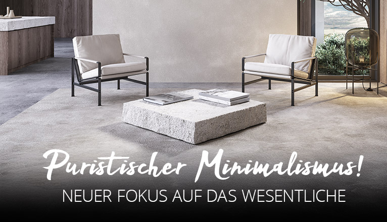 Puristischer Minimalismus - Neuer Fokus auf das Wesentliche - Zwei schlichte Sessel und ein tiefer Tisch aus einem weißen quaderförmigen Stein in einem hellen Raum in reduzierter Betonoptik