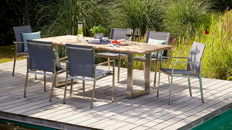 outdoor Gartenstühle bei Moebel-Shop - Ein outdoor Gartentisch mit passenden outdoor Gartenstühlen aus Alu und Holz, bespannt mit einem grauen Kunststoffgewebe, auf einer Terrasse